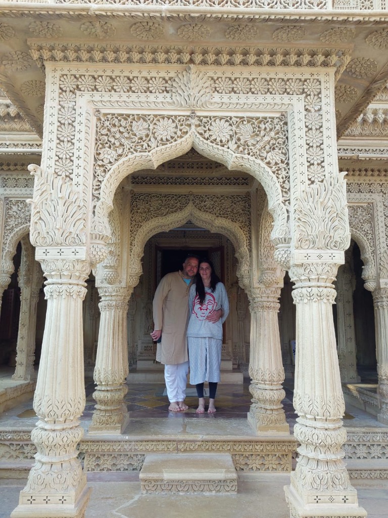 Couple framed under the intricately carved Jain temple arches in Jaisalmer