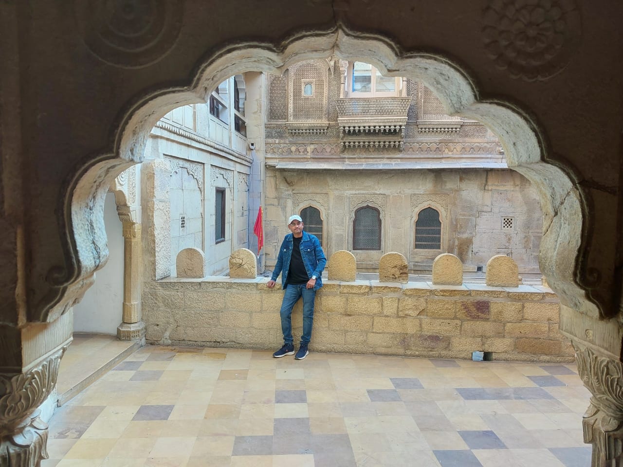 Harry framed in an ornate stone-carved haveli archway